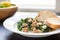 zuppa toscana in white bowl, bread slice resting on edge