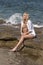 Î’londe woman sitting on rocks