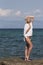 Î’londe woman standing on sea rocks