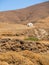 Î‘ white chapel in the dry Cycladic landscape