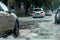 Ð’riving car on flooded road during flood caused by torrential rains. Cars float on water, flooding streets. Splash on car.