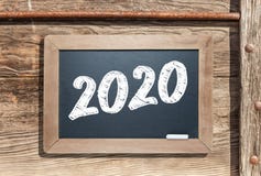 2020 Written On Slate Chalk Board Against Aged Wood And Pipe Background Stock Image 2020 Written On Slate Chalk Board Against Aged Wood And Pipe Background Stock Image