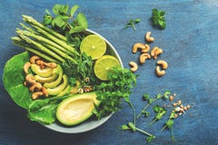 A Bowl Of Green Vegan Salad With Asparagus, Avocado, Lettuce, Basil, Mint, Microgreen, Lime And Cashew Nuts, Blue Rustic Stock Images A Bowl Of Green Vegan Salad With Asparagus, Avocado, Lettuce, Basil, Mint, Microgreen, Lime And Cashew Nuts, Blue Rustic Stock Images