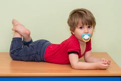 A Boy Lying On A Closet With A Pacifier Royalty Free Stock Photography A Boy Lying On A Closet With A Pacifier Royalty Free Stock Photography