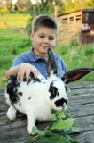 A Boy With A Rabbit In The Garden Stock Photos