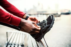 A Close-up Of A Young Sporty Black Man Runner Tying Shoelaces Outside In A City. Royalty Free Stock Image A Close-up Of A Young Sporty Black Man Runner Tying Shoelaces Outside In A City. Royalty Free Stock Image