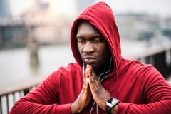 A Close-up Of Black Man Runner With Earphones And Hood On His Head In A City. Copy Space. Stock Images