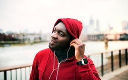 A Close-up Of Black Man Runner With Earphones And Hood On His Head In A City. Copy Space. Stock Images A Close-up Of Black Man Runner With Earphones And Hood On His Head In A City. Copy Space. Stock Images