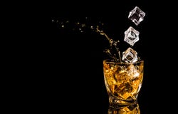 A Glass Of Whiskey With Splashes From The Ice Cube Over Black Background. Alcohol Splashes. Whisky Or Cognac Or Another Type Of Royalty Free Stock Images A Glass Of Whiskey With Splashes From The Ice Cube Over Black Background. Alcohol Splashes. Whisky Or Cognac Or Another Type Of Royalty Free Stock Images
