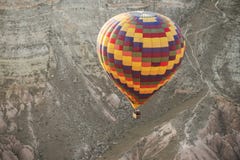 A Large Multi-colored Balloon Flying Over A Mountain Gorge. Royalty Free Stock Photography