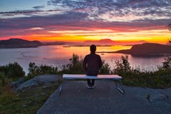A Lone Man Sitting On A Bench Overlooking Islands And Ocean At Dramatic Sunset Royalty Free Stock Photo