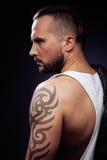 A Man With Tattooes On His Arms. Silhouette Of Muscular Body. Caucasian Brutal Hipster Guy With Modern Haircut, Looking Stock Photo