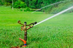 A Metal Automatic Water Sprinkler In The Field Stock Image