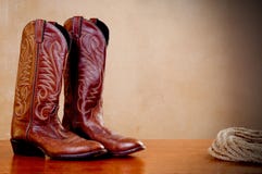 A Pair Of Brown Cowboy Boots And A Coil Of Rope Stock Photos