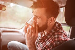 A Picture Of Sick Guy Sneezing In Napkin. He Is Looking Straight. Young Man Is Suffering. Stock Photos