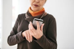 A Positive Modern Elderly Woman Is Holding A Cell Phone And Is Using It. The Older Generation And Modern Technology. Royalty Free Stock Photography