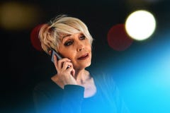 A Successful Positive Elderly Female Consultant Is Negotiating A Cell Phone. Communication Between People Using Modern Royalty Free Stock Images A Successful Positive Elderly Female Consultant Is Negotiating A Cell Phone. Communication Between People Using Modern Royalty Free Stock Images