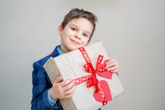 Aanbiddelijke jongen met een giftdoos op een lichte achtergrond royalty-vrije stock fotografie Aanbiddelijke jongen met een giftdoos op een lichte achtergrond royalty-vrije stock fotografie
