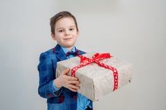 Aanbiddelijke jongen met een giftdoos op een lichte achtergrond stock foto's Aanbiddelijke jongen met een giftdoos op een lichte achtergrond stock foto's