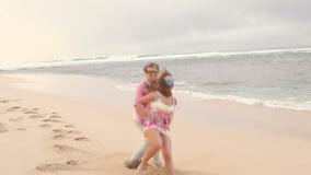 Aantrekkelijk gezond paar die pret hebben die samen lopend op strand zijn stock footage Aantrekkelijk gezond paar die pret hebben die samen lopend op strand zijn stock footage