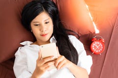 Aantrekkelijk vrouwenkielzog omhoog in ochtend op een bed Het charmeren van mooi meisje speelt online Internet op mobiele telefoo stock foto Aantrekkelijk vrouwenkielzog omhoog in ochtend op een bed Het charmeren van mooi meisje speelt online Internet op mobiele telefoo stock foto