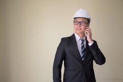 Aantrekkelijke Aziatische Techniek in een kostuum die mobiele telefoon met behulp van Royalty-vrije Stock Afbeeldingen Aantrekkelijke Aziatische Techniek in een kostuum die mobiele telefoon met behulp van Royalty-vrije Stock Afbeeldingen