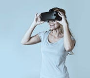 Aantrekkelijke blonde vrouw die de visiebeschermende brillen dragen die van de hoofdtelefoonvr virtuele werkelijkheid op video le royalty-vrije stock afbeeldingen Aantrekkelijke blonde vrouw die de visiebeschermende brillen dragen die van de hoofdtelefoonvr virtuele werkelijkheid op video le royalty-vrije stock afbeeldingen