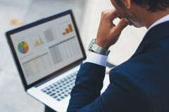 Aantrekkelijke elegante zakenman die eigentijdse notitieboekjezitting buiten het bureau gebruiken Grafieken en diagramm op laptop Stock Afbeelding Aantrekkelijke elegante zakenman die eigentijdse notitieboekjezitting buiten het bureau gebruiken Grafieken en diagramm op laptop Stock Afbeelding