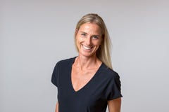 Aantrekkelijke gelukkige blonde vrouw met een enthousiaste glimlach stock afbeeldingen Aantrekkelijke gelukkige blonde vrouw met een enthousiaste glimlach stock afbeeldingen