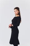 Aantrekkelijke jonge vrouw in een zwarte kleding die en camera glimlachen bekijken stock fotografie Aantrekkelijke jonge vrouw in een zwarte kleding die en camera glimlachen bekijken stock fotografie