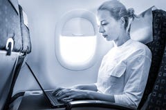Aantrekkelijke Kaukasische vrouwelijke passagier die bij moderne laptop computer werken die draadloze verbinding aan boord van co stock foto Aantrekkelijke Kaukasische vrouwelijke passagier die bij moderne laptop computer werken die draadloze verbinding aan boord van co stock foto