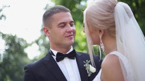 Abraço considerável do noivo sua noiva bonita Recém-casados que andam no parque Mulher do cabelo louro no vestido de casamento el video estoque Abraço considerável do noivo sua noiva bonita Recém-casados que andam no parque Mulher do cabelo louro no vestido de casamento el video estoque