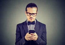 Absorbujący smutny mężczyzna główkowanie co odpowiadać otrzymywająca wiadomość tekstowa na telefonie komórkowym fotografia royalty free Absorbujący smutny mężczyzna główkowanie co odpowiadać otrzymywająca wiadomość tekstowa na telefonie komórkowym fotografia royalty free