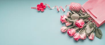 Accogliere il mazzo pallido rosa delle rose in sacchetto della spesa con il nastro sul fondo del blu di turchese, vista superiore immagini stock Accogliere il mazzo pallido rosa delle rose in sacchetto della spesa con il nastro sul fondo del blu di turchese, vista superiore immagini stock