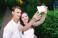 Accoppi la fabbricazione del selfie insieme in un parco verde fotografia stock libera da diritti Accoppi la fabbricazione del selfie insieme in un parco verde fotografia stock libera da diritti