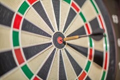 Accurate dart sight hitting center of target, dartboard and dart, blurred background stock image Accurate dart sight hitting center of target, dartboard and dart, blurred background stock image