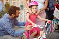 Achats de m?re au casque heureux de bicyclette de fille dans le magasin de v?lo image stock Achats de m?re au casque heureux de bicyclette de fille dans le magasin de v?lo image stock