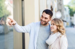 Achats heureux de couples et regarder la fenêtre de boutique Image stock Achats heureux de couples et regarder la fenêtre de boutique Image stock