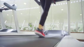 Achtermening van vrouwelijke benen die op tredmolengymnastiek lopen, gemotiveerde vrouw opleiding stock videobeelden Achtermening van vrouwelijke benen die op tredmolengymnastiek lopen, gemotiveerde vrouw opleiding stock videobeelden
