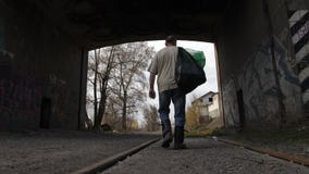 Achtermenings werkloze mens die met vuilniszakken loopt stock videobeelden Achtermenings werkloze mens die met vuilniszakken loopt stock videobeelden