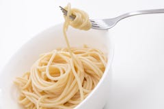 Aclare las pastas cocinadas de los espaguetis en el cuenco blanco y en la bifurcación, en el fondo blanco fotos de archivo Aclare las pastas cocinadas de los espaguetis en el cuenco blanco y en la bifurcación, en el fondo blanco fotos de archivo