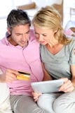 Acople o assento no sofá e a compra com cartão de crédito foto de stock Acople o assento no sofá e a compra com cartão de crédito foto de stock