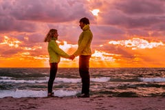 Acople o homem e a mulher no amor que está no beira-mar da praia que guarda h foto de stock Acople o homem e a mulher no amor que está no beira-mar da praia que guarda h foto de stock