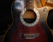Acoustic guitar resting against a wooden background stock photo Acoustic guitar resting against a wooden background stock photo