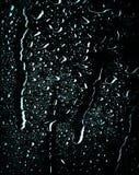 Acqua e gocce di pioggia sulla vista di vetro e astratta, gocce di pioggia su fondo/su gocce di vetro blu su vetro dopo rainblack immagine stock libera da diritti Acqua e gocce di pioggia sulla vista di vetro e astratta, gocce di pioggia su fondo/su gocce di vetro blu su vetro dopo rainblack immagine stock libera da diritti
