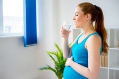 Acqua potabile della donna incinta fotografia stock Acqua potabile della donna incinta fotografia stock