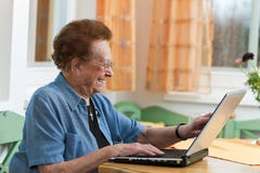 Actieve oudste met laptop in Vrije tijd stock afbeeldingen Actieve oudste met laptop in Vrije tijd stock afbeeldingen