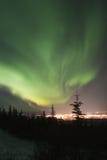Active Aurora Borealis In The Sky Over Town Lights Royalty Free Stock Image