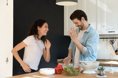 Active young spouses dancing at kitchen resting from cooking food