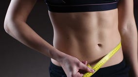 Active woman demonstrating flat belly, measuring waist with tape, weightloss stock video footage Active woman demonstrating flat belly, measuring waist with tape, weightloss stock video footage